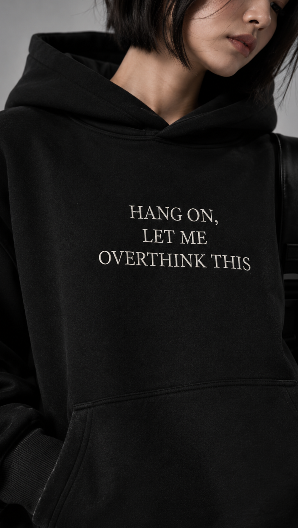 Embroidered chest lettering shown close up on the Dripzy black oversized fleece hoodie